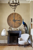 A clock keeps watch over a European white mud beeskep and a colorful taxidermy 