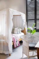 Canopy bed and Malawi cane chair in children's room