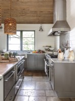 Gray cabinetry and stainless steel appliances encapsulate the homeâ€™s dual aesthetics. 