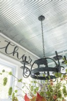 A metal chandelier connects visually to the Gather sign.