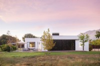 Modern house with closed metal screens in countryside setting 