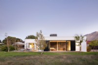 Modern house with open metal screens in countryside setting 