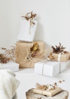 Brown and white wrapped Christmas gifts with natural decorations