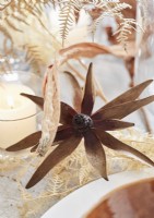 Detail of dried flower arrangement and lit candle 