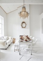 Chandelier over table in white country dining room at Christmas