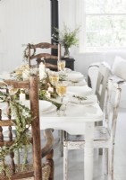 Rustic white dining table laid for Christmas dinner