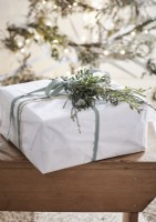 Detail of white Christmas present with natural decoration and ribbon 