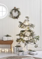 White wooden Christmas tree decorated with natural garlands