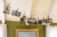 Old photographs and postcards casually hung with clothespins from a line epitomize the beach house lifestyle. 