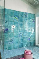 Glass tile commissioned from a local artist creates a sparkling mural in the main bathroom. 