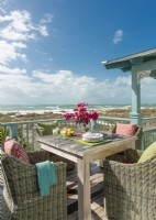 Classic and comfortable wicker, and colors as bright as a tropical fruit basket extend a warm welcome on the balcony overlooking the beach.