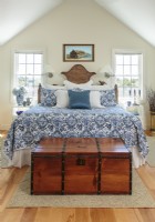  Tucked under the eaves, the master bedroom features a vintage wood trunk that came with the house. 