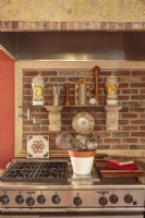 Adding to the kitchenâ€™s rusticity, a hood encased in tiles and bricks tops the professional-grade stove and adds noteworthy character.