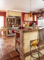 With its warm tones, plaster walls, stones, bricks and tiles, the kitchen is a study in Tuscan style. 