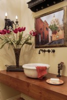 A baptismal fount from a European chapel is put to service in the guest bathroom.