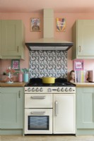Cream coloured cooker in a Shaker style retro kitchen with a patterned tiled splashback