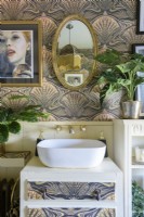 Art nouveau decorative wallpaper behind a hand basin set on an upcycled painted chest of drawers