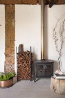 Woodburning fireplace in front of exposed brick wall