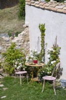 Small metal bistro table and chairs in rustic country garden