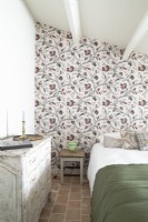 Country bedroom with floral wallpapered feature wall