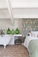Roll top bath in feminine country bedroom with feature wall