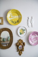 Wall mounted display of ceramic plates and gold mirrors