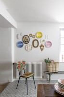 Display of eclectic and vintage plates on wall of dining room