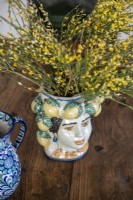 Detail of painted ceramic vase with yellow flowers