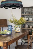 Decorative painted ceramic vase on wooden country dining table