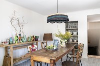 Eclectic display of ceramics on wooden side table in dining room