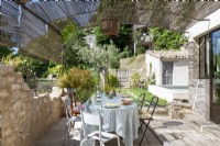 Shaded outdoor dining area of country house in summer