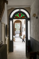 Stained glass windows over doorway with view to corridor