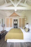 Brown and white country bedroom with vaulted ceilings and bathroom