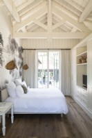 White country bedroom with vaulted ceiling