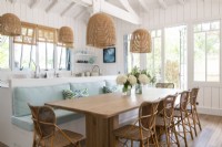 Built-in bench seating around dining table in country kitchen-diner