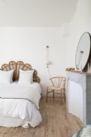 Decorative wicker headboard in white country bedroom