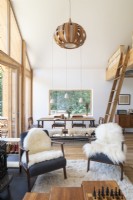 Sheepskin rugs on armchairs in open plan living and dining space