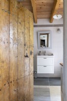 View through old studded wooden door to bathroom