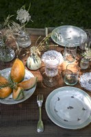 Detail of rustic outdoor dining table laid for lunch in summer 