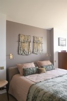 Fabric wall hangings above bed in modern bedroom