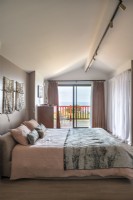Modern bedroom with sliding doors to balcony and coastal view