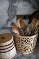 Basket of wooden spoons on marble kitchen worktop - detail