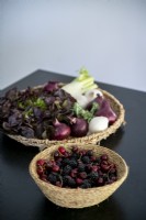Baskets of fruit and vegetables on black kitchen worktop