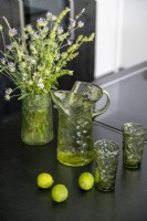 Glassware and flowers on black kitchen worktop