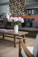 Flowers in vase on wooden coffee table in modern living room