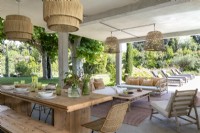 Covered outdoor dining area with view of seating areas and garden