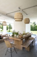 Wooden outdoor dining table and bench with view of swimming pool
