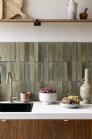 Stone tiled splashbacks and sink in contemporary kitchen