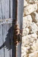 Old metal handle on rustic wooden shutter - detail