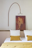Modern wall lamp and painting above bed